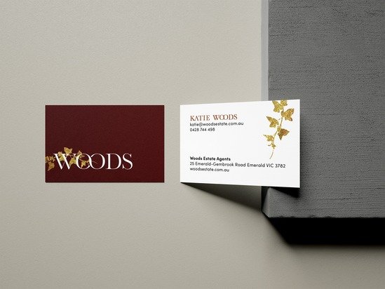 Business card for Katie Woods with contact information, next to a Woods Estate Agents card, on a gray and dark surface background.