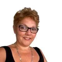 A middle-aged woman with short hair and glasses smiling at the camera.