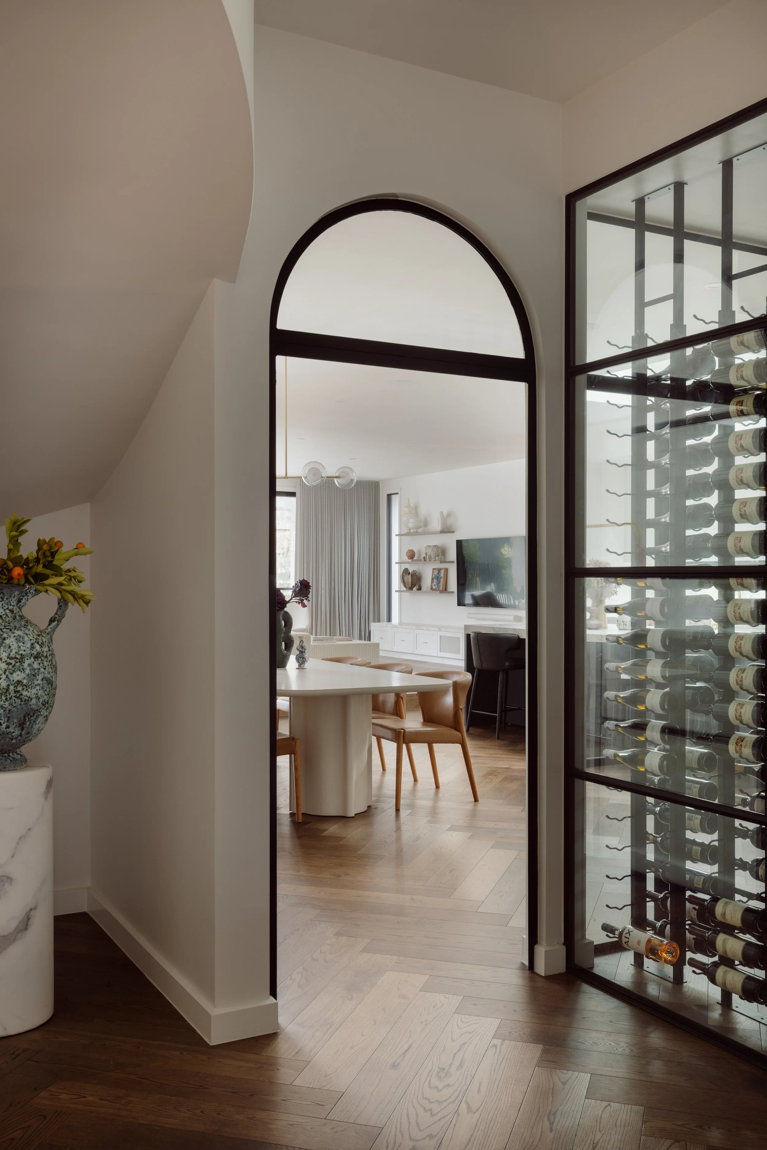 Arched doorway with view of wine room and dining