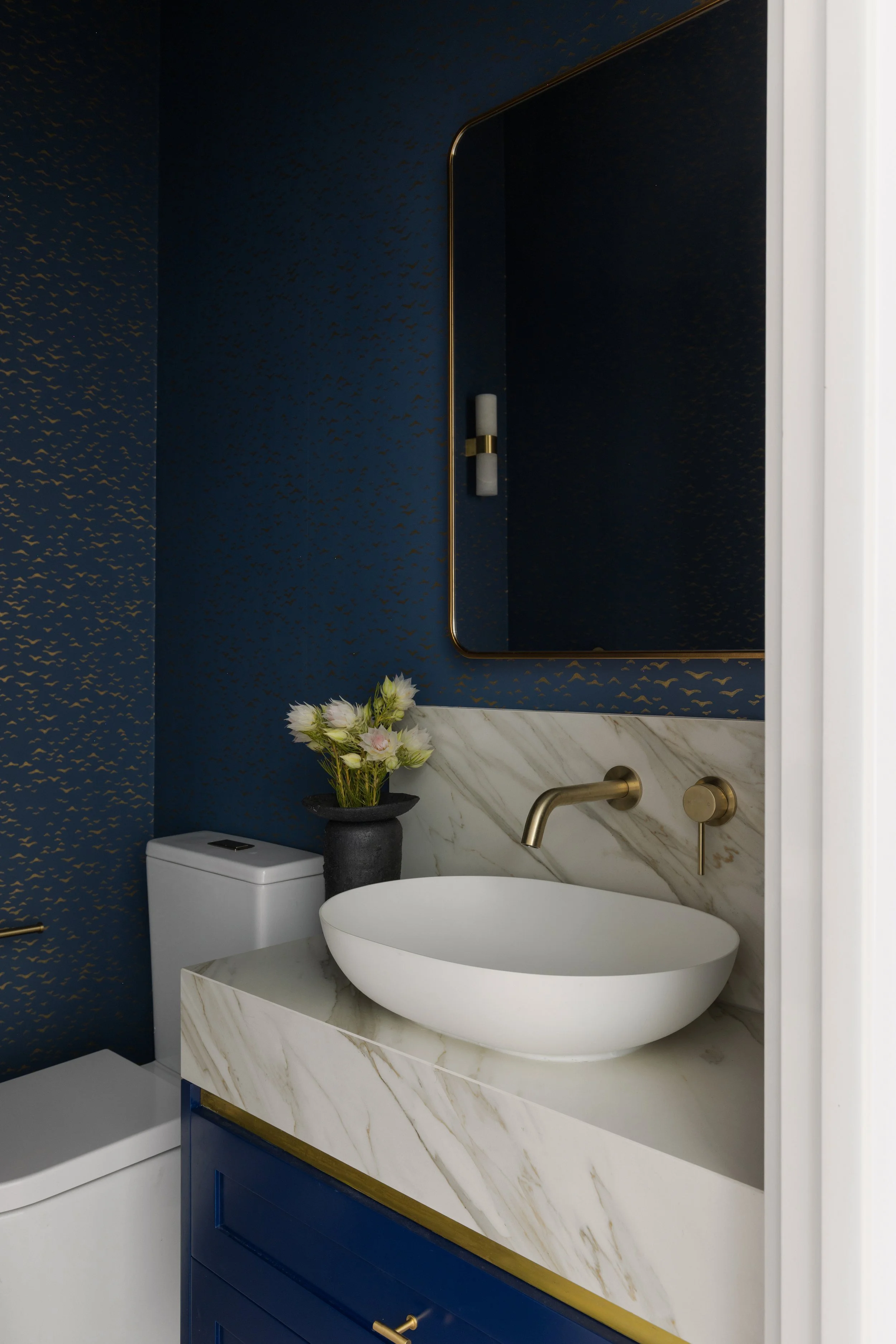 Elegant powder room with indigo and gold wallpaper