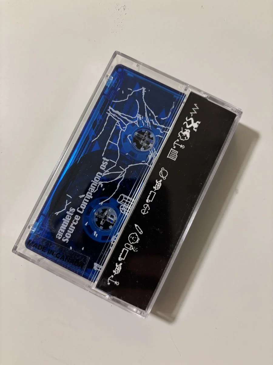 A cassette tape with a clear case showing a blue tape and black label, featuring white icons and text.