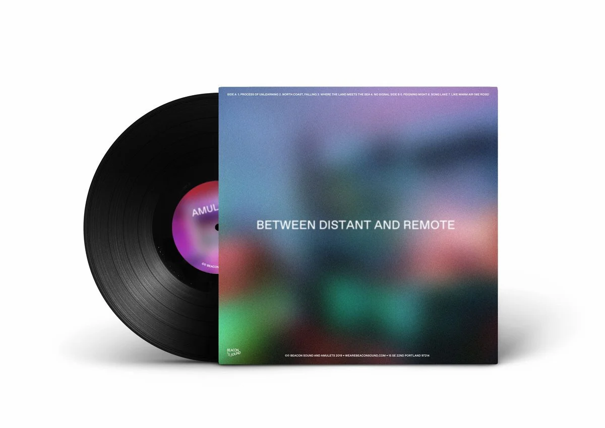 A black vinyl record partially covered by a colorful, blurry album cover with the title 'Between Distant and Remote' and a purple and pink gradient label.