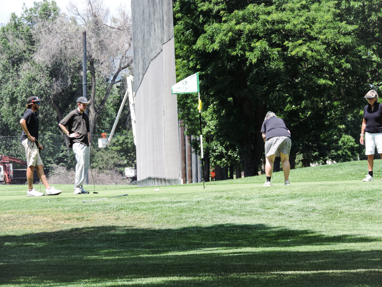 The opposing team lines up their putt for the win on the 9th green at the City Park Nine Golf Course, on July 11th 2025 at 12:15 pm for a photgraphy essay