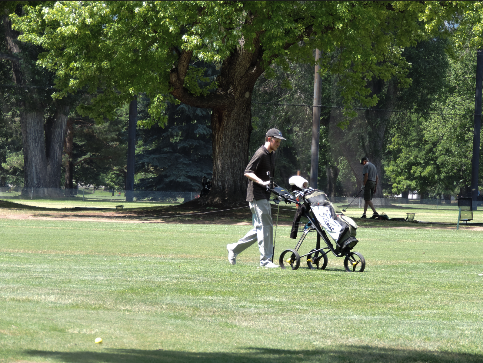 Man approaching the 9th green at City Park Nine Golf Course, on July 11th 2025 at 12:15 pm for a photgraphy essay