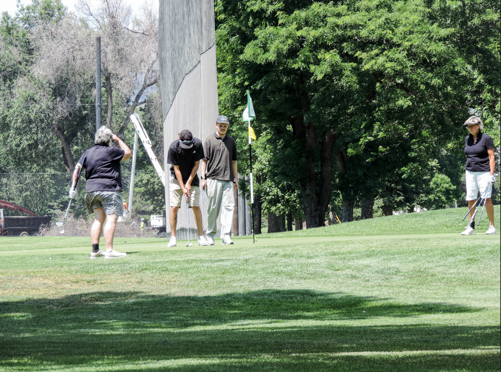 Opponents putting a "feel good" putt after the winning putt is made, on the 9th green of the city park golf course on July 11th 2025 at 12:15 pm for a photgraphy essay