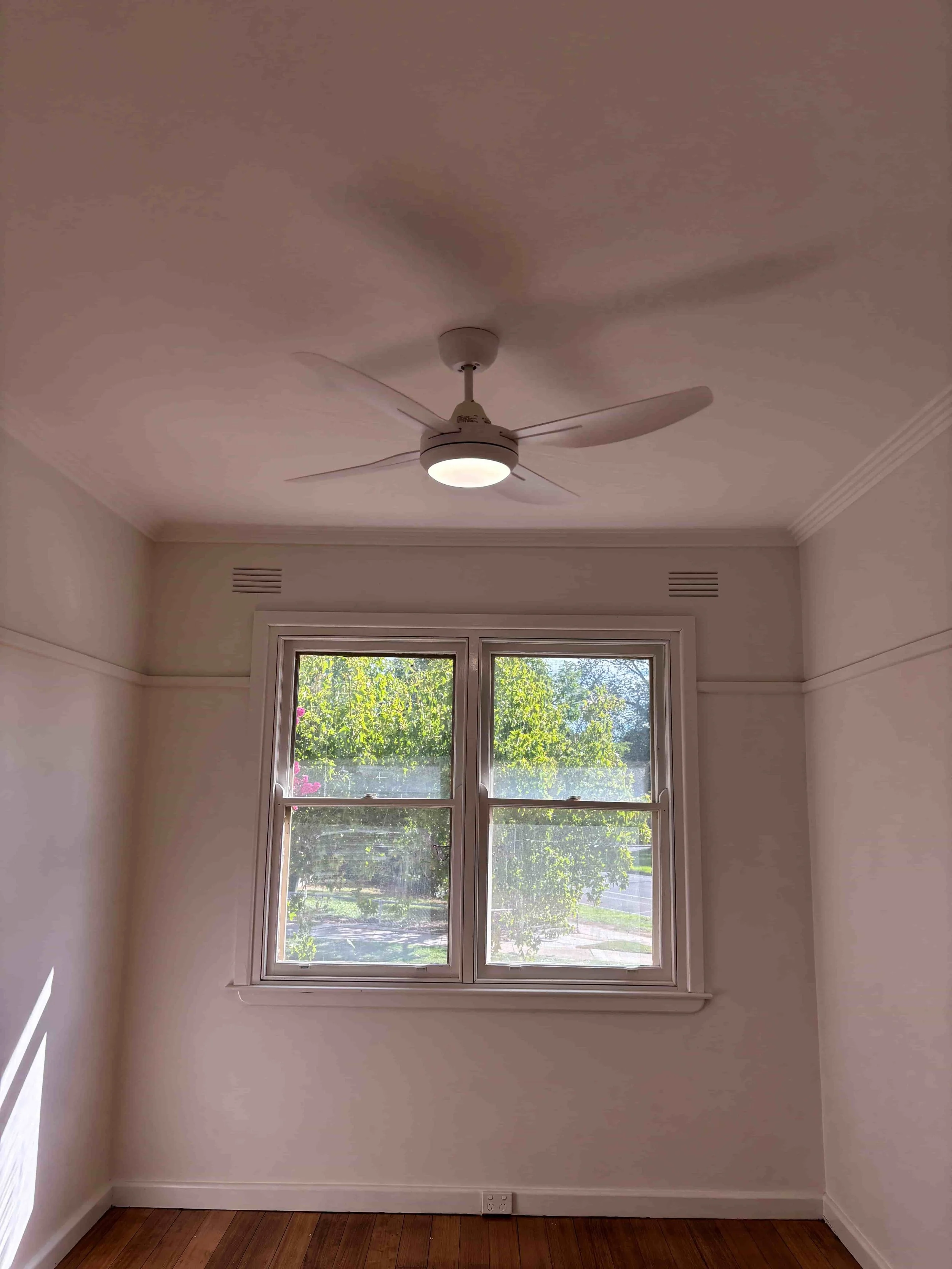 Renovated bedroom at Hargreaves Street Bendigo featuring restored timber flooring, ceiling fan, and natural light