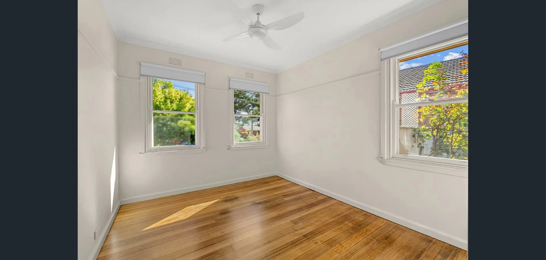 Bright renovated bedroom at Hargreaves Street in Bendigo featuring polished timber flooring and updated windows by AMW Builders.