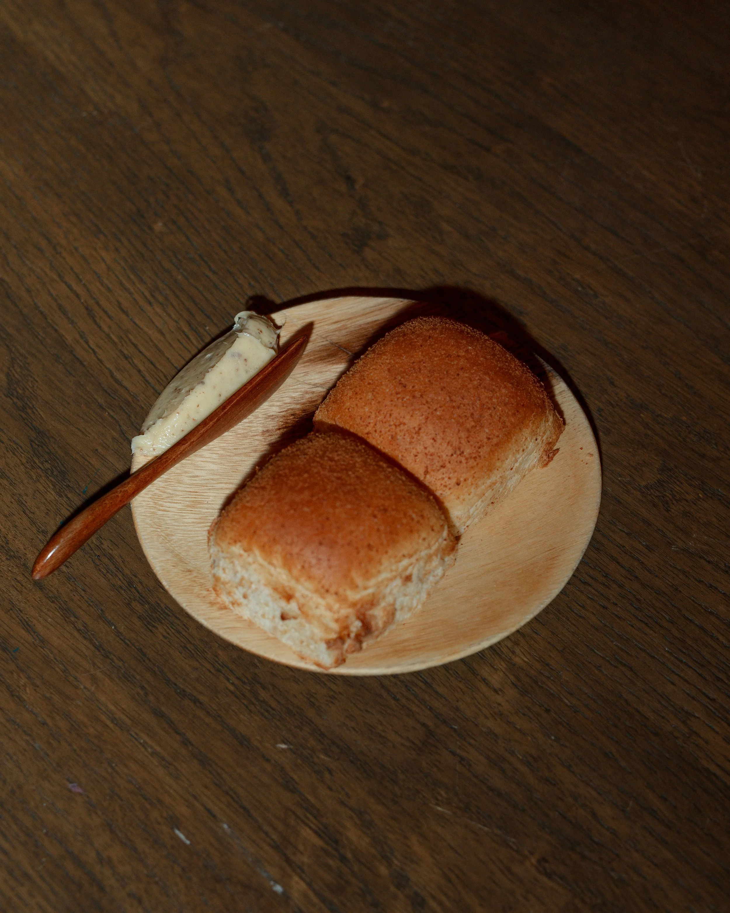 A slice of Filipino pandesal with latik butter