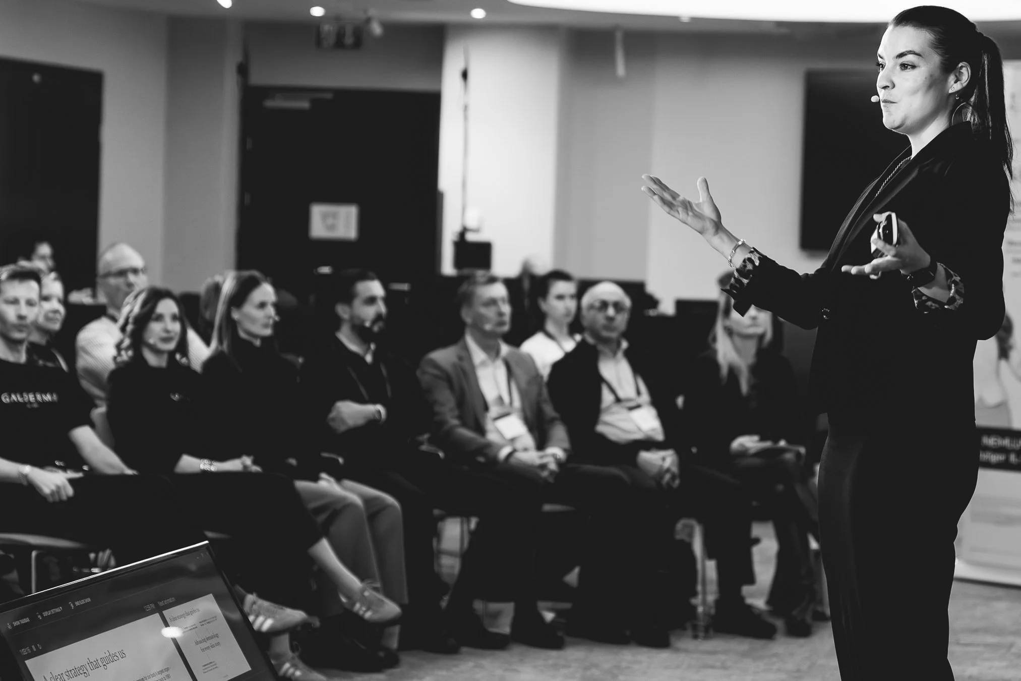 A woman giving a presentation in front of an audience in a conference room.Galderma Event Vienna