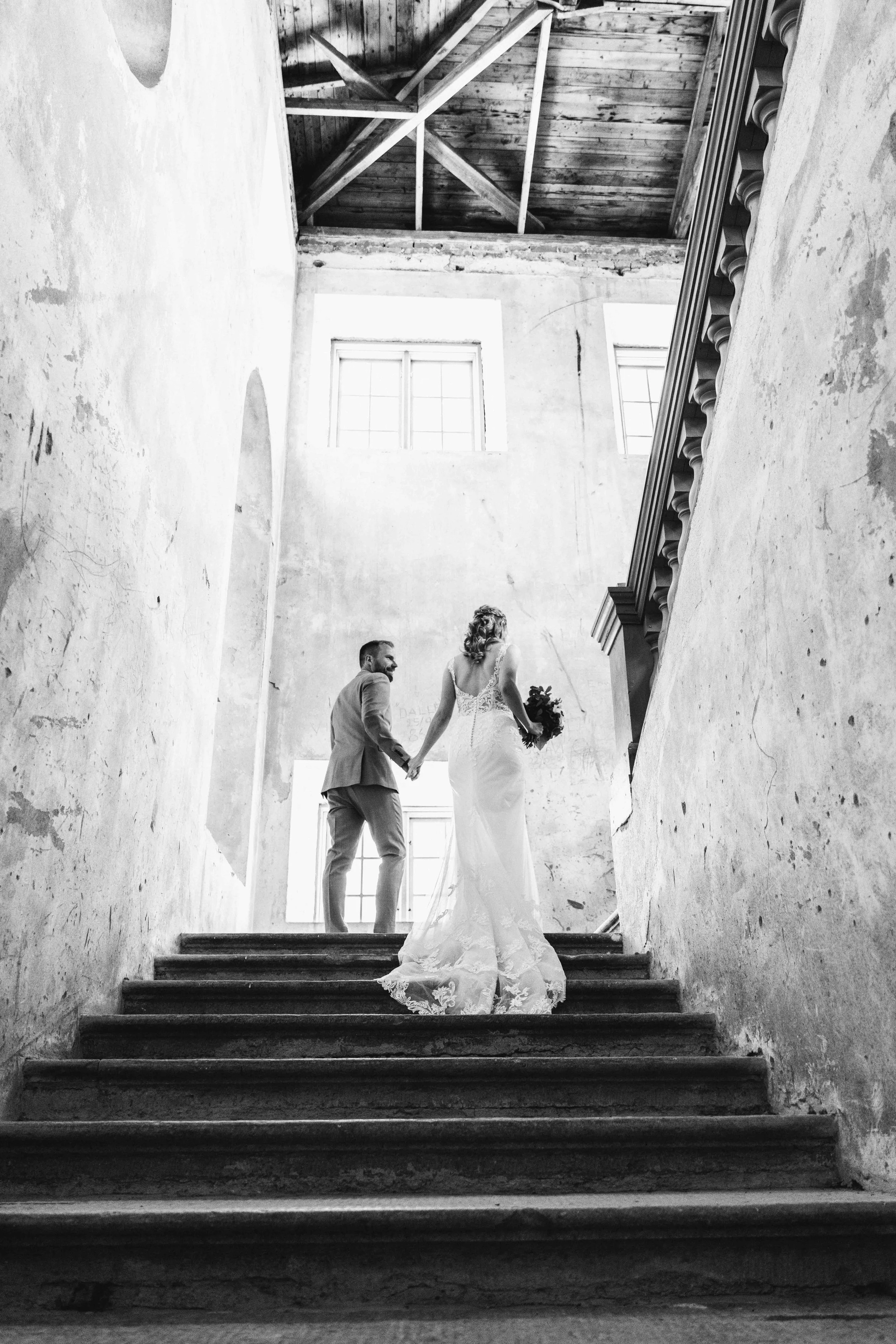 Johanna och Stefan går uppför slottets trappa, fotograferade bakifrån i svartvitt.