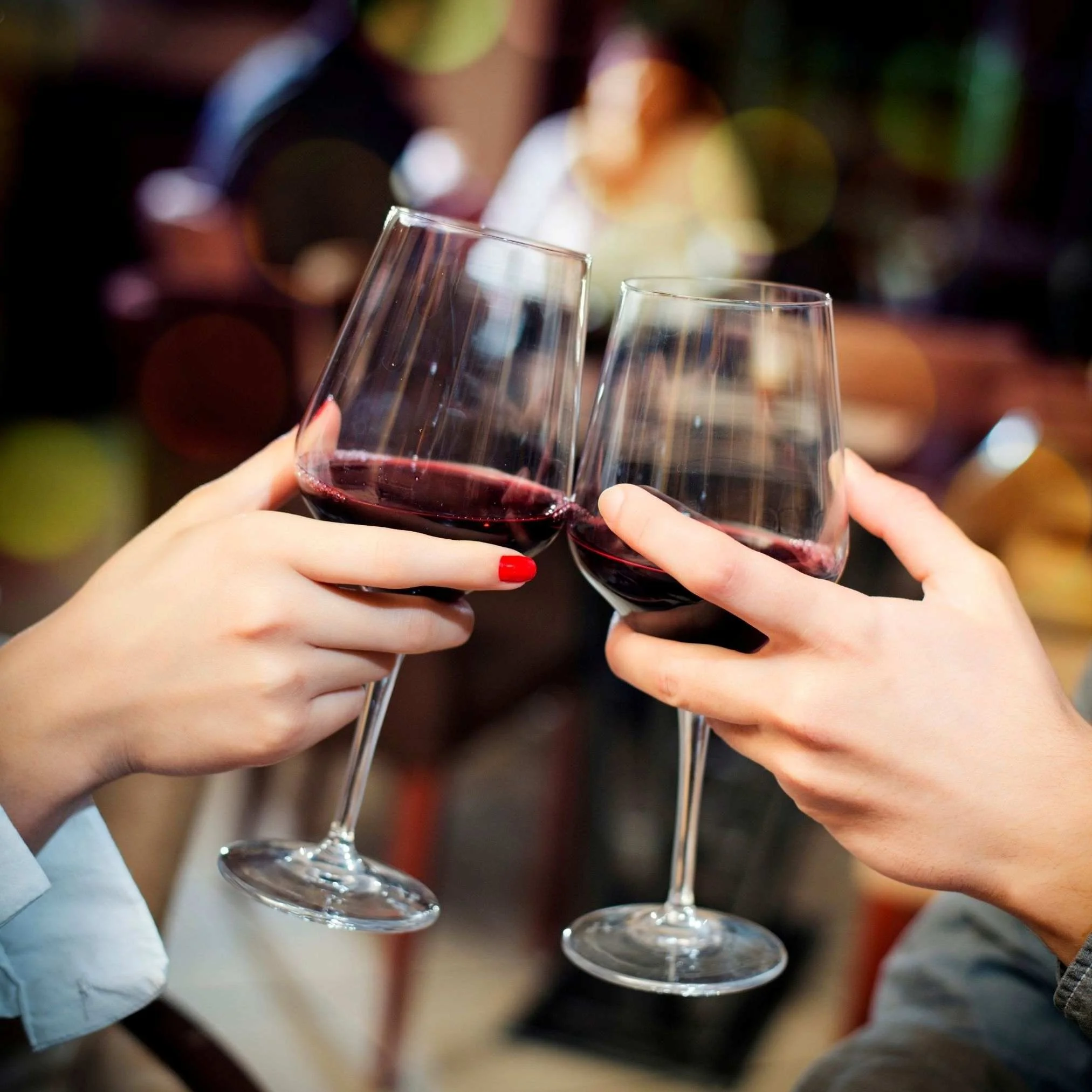 two red wine glasses cheersing