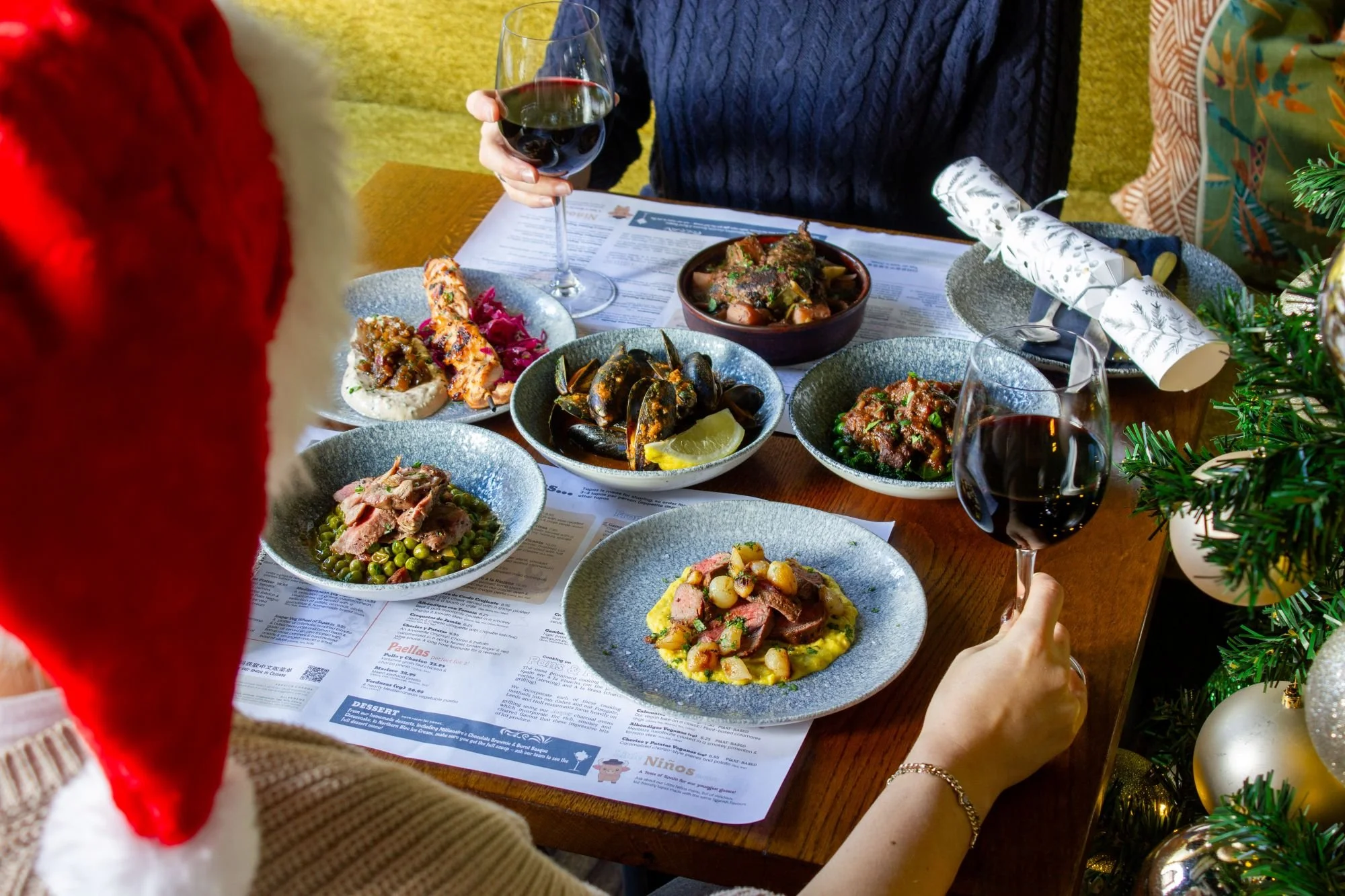 Table of Christmas tapas dishes with someone wearing santa hat