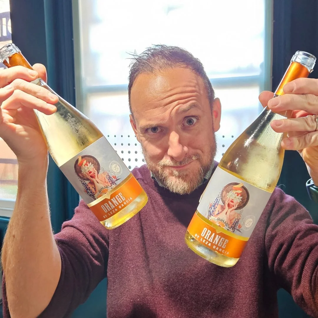 Jim holding two bottle of the Orange Leza Garcia