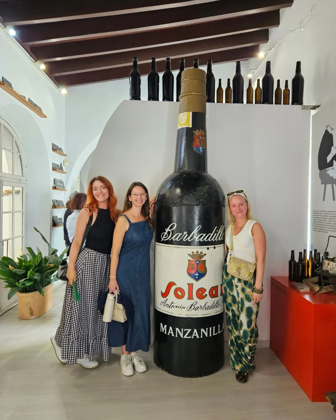 The team standing next to a large bottle of sherry