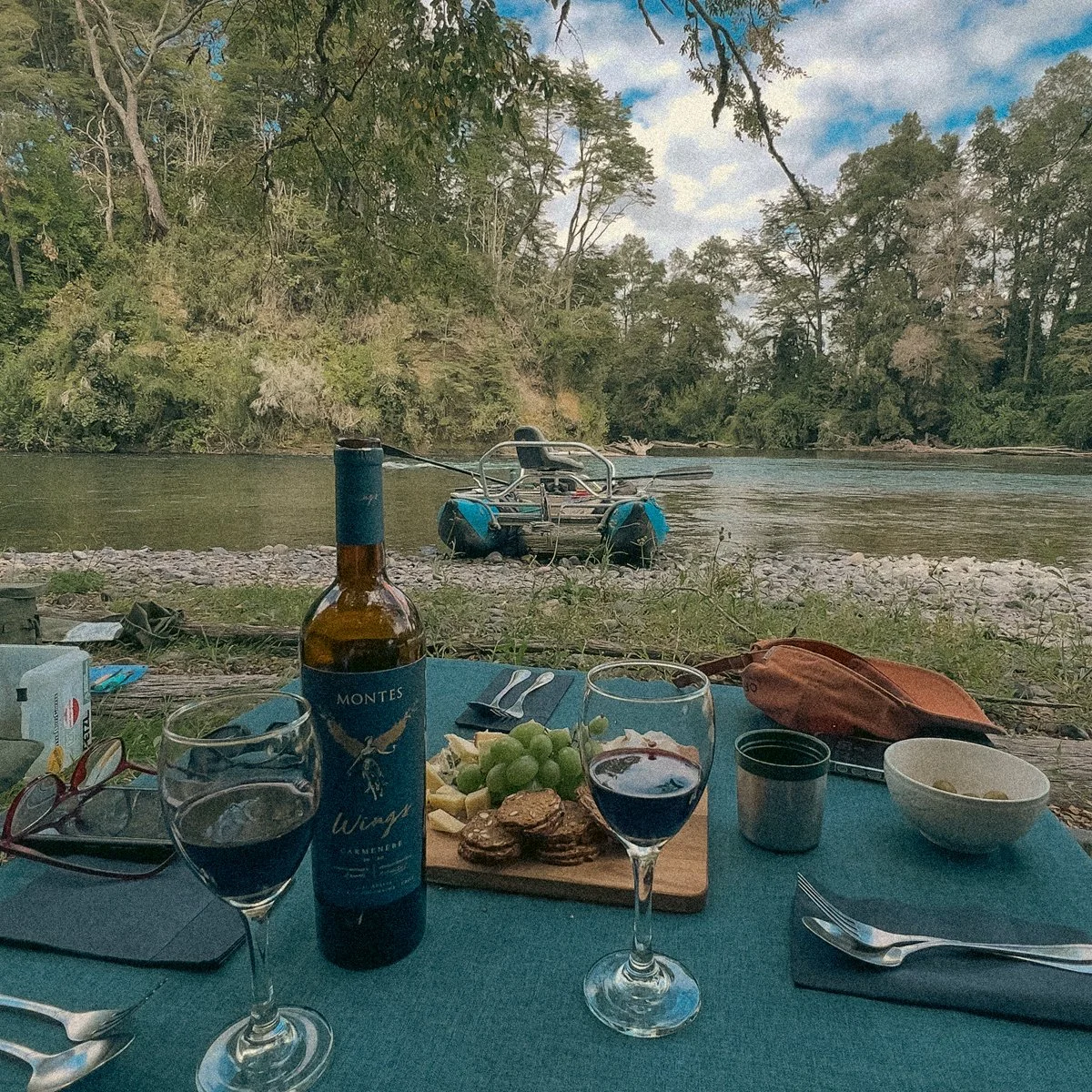 Gourmet riverside lunch with fine Chilean wine and charcuterie board during a private fly fishing expedition in Patagonia.