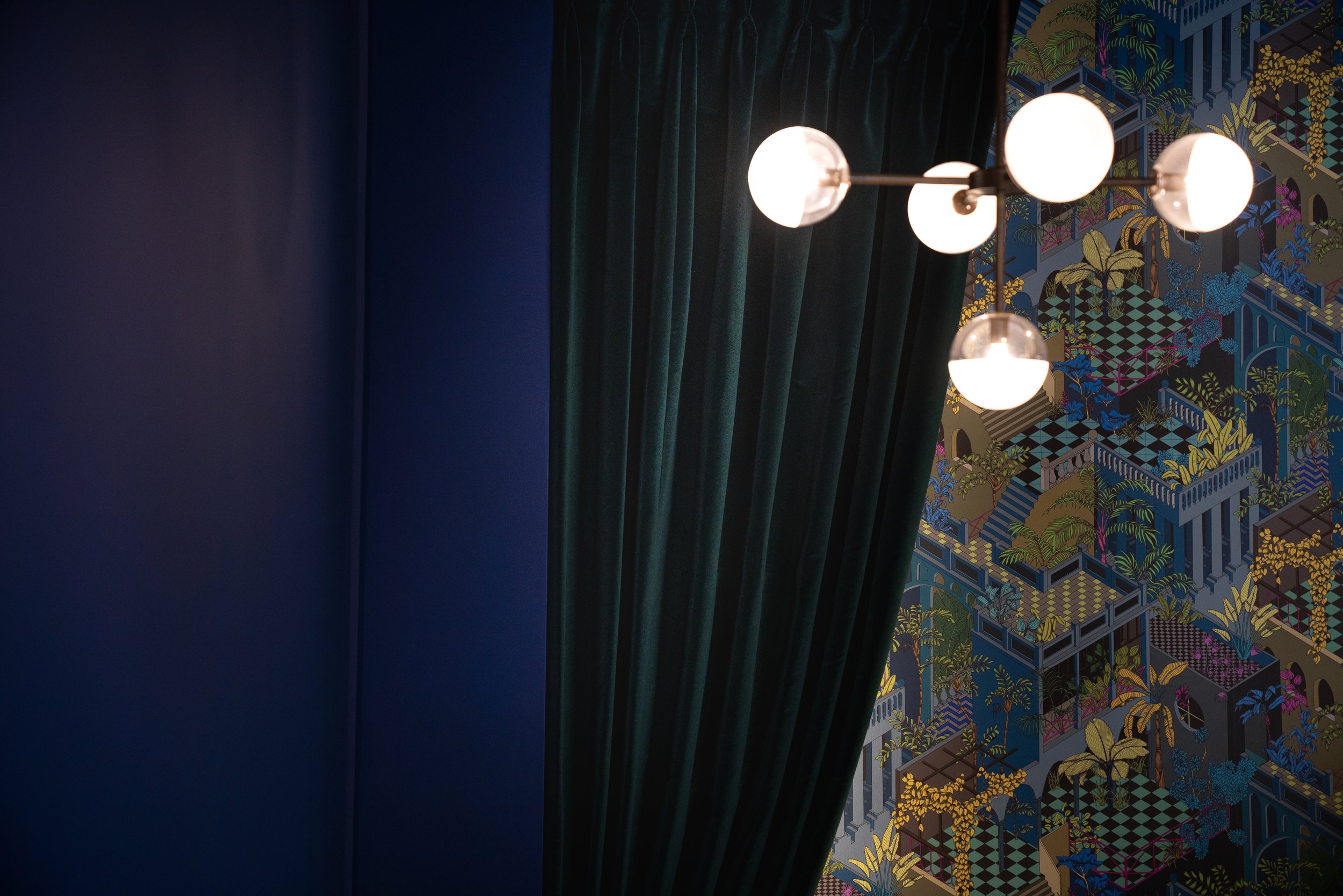 Close-up of elaborate Cole and Son wallpaper adding sophisticated texture and urban decadence to the workspace walls.