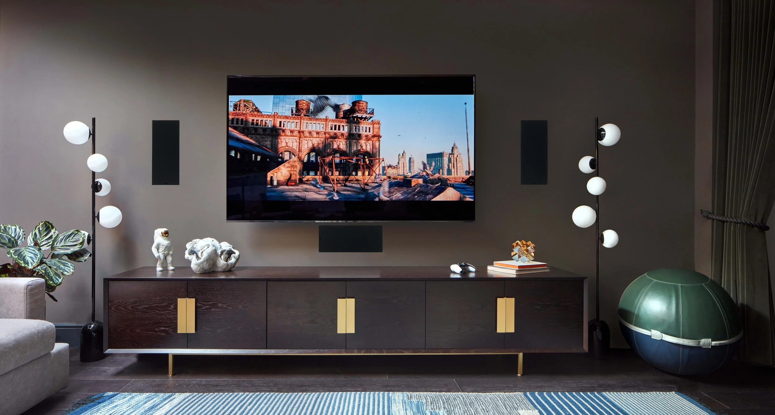 Zoomed-in view of the cinema room's left side, showcasing bespoke cabinetry in dark oak, leather swiss balls and elegant finishes