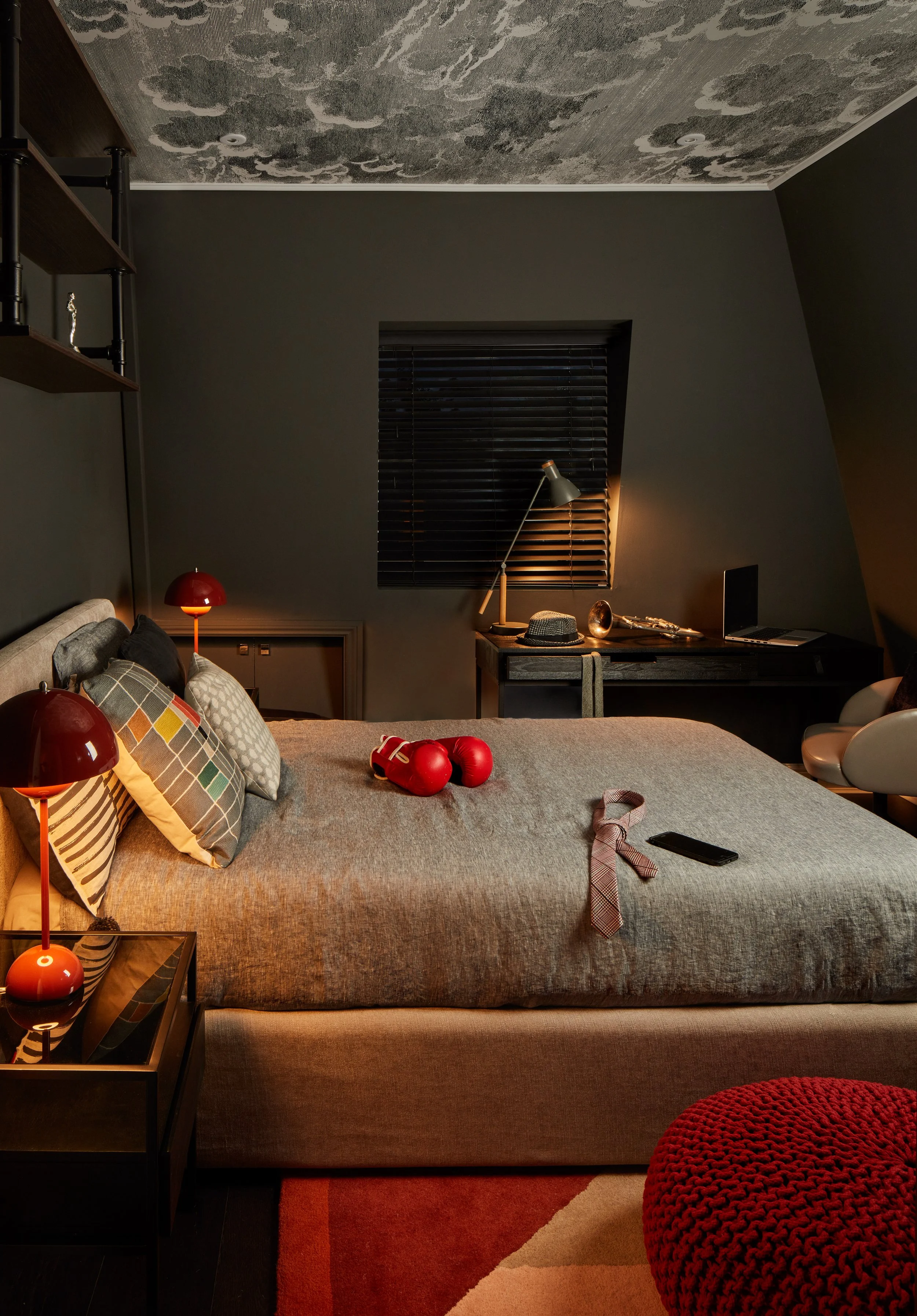 Teenage bedroom with a superhero theme, with dark wall colours from Little Greene and Nuvole wallpapers by Fornasetti from Cole&Son