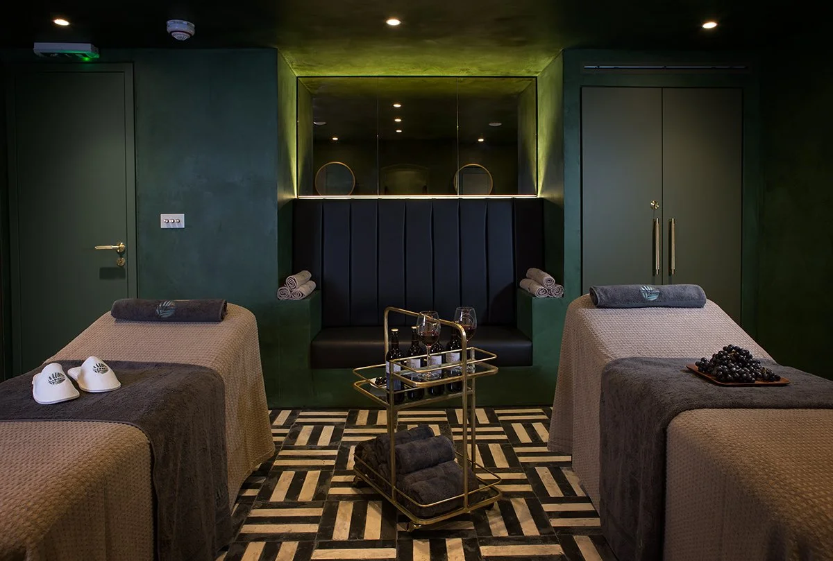 Spa black leather seating details with black and white tiles and deep green walls