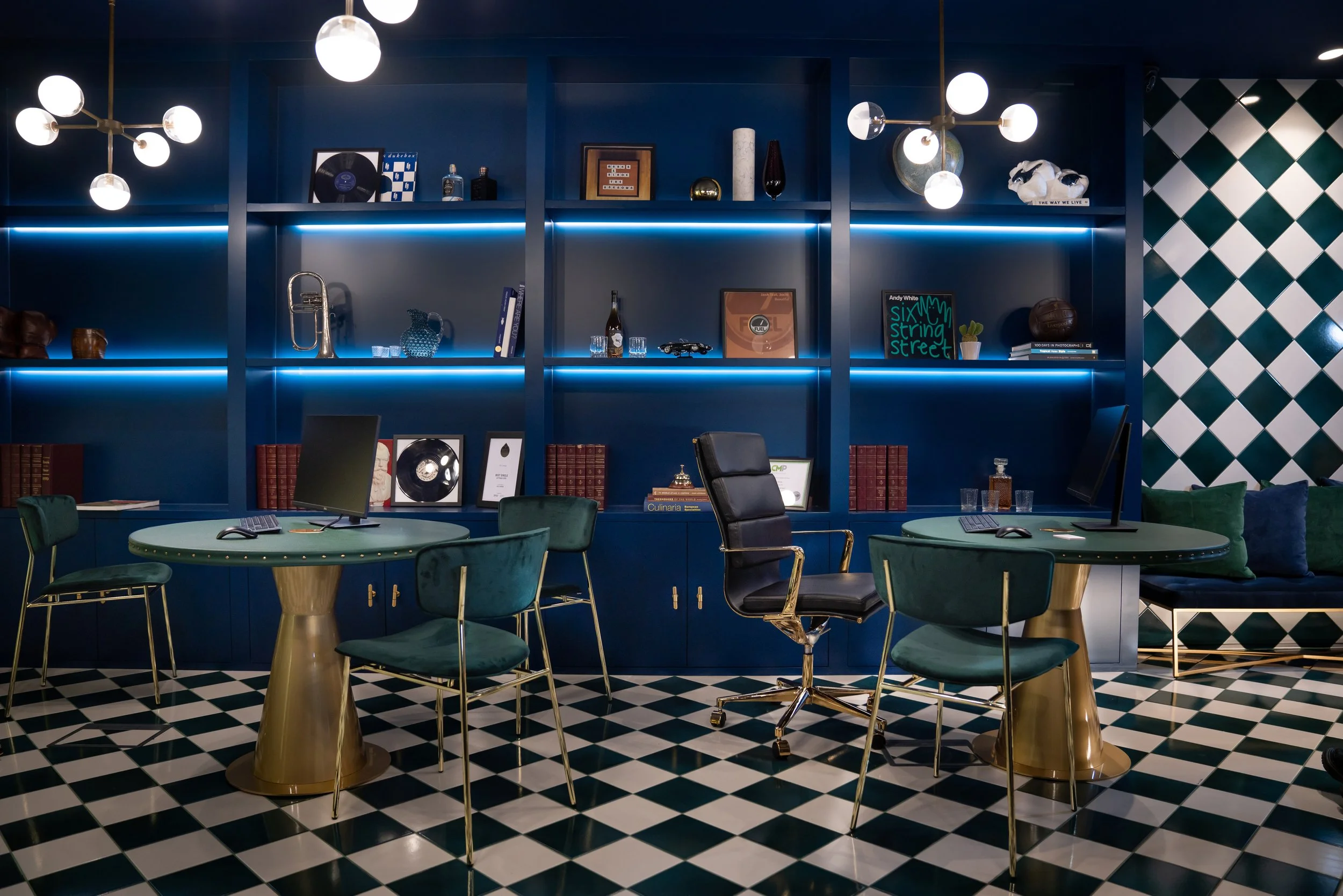 Bespoke dimly lit bookshelf displaying curated ornaments, illuminated by stylish pendant lights for a refined look.