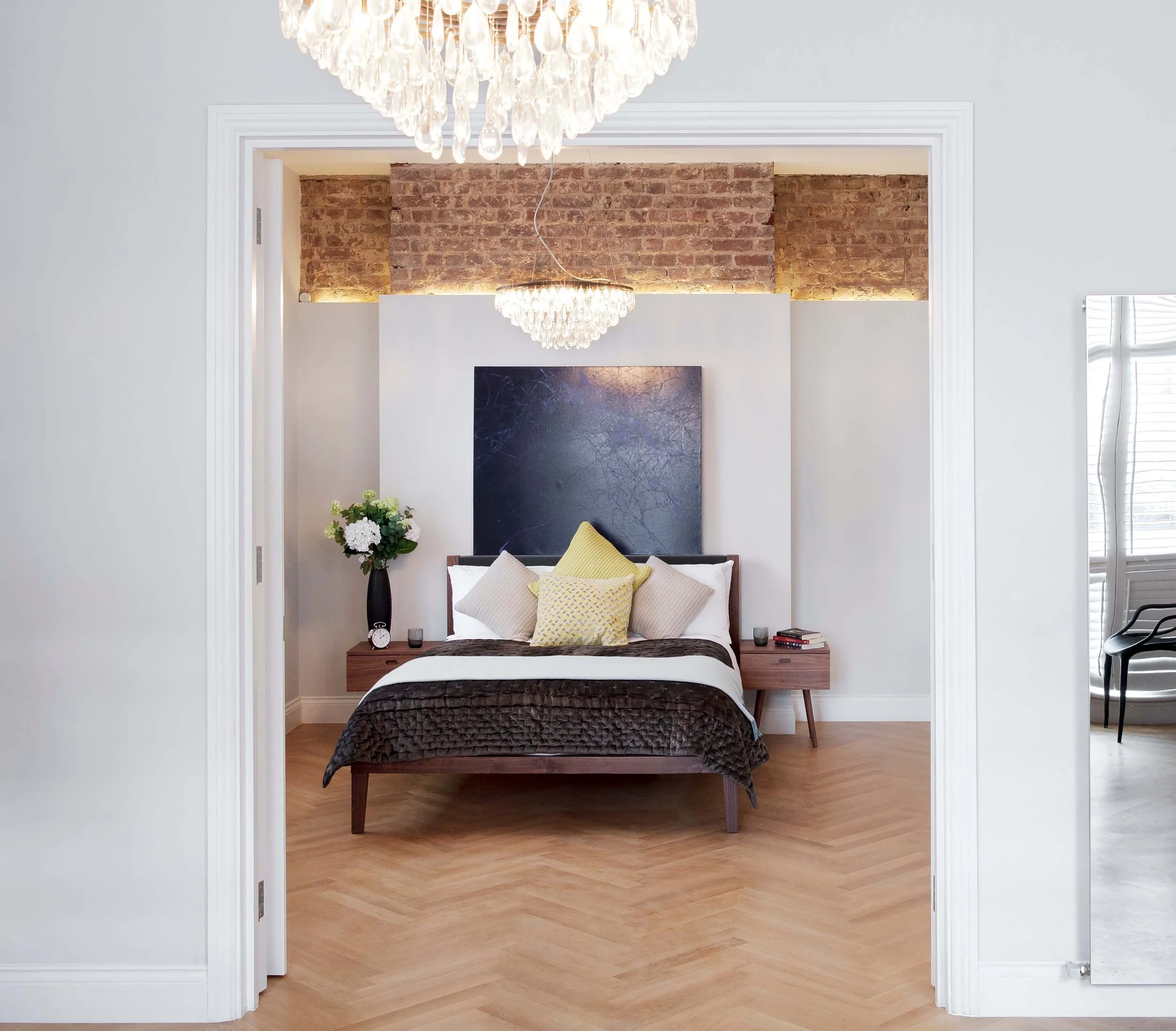 Bedroom showcasing the elegant blend of heritage and modern design with partly exposed original bricks and soft lighting