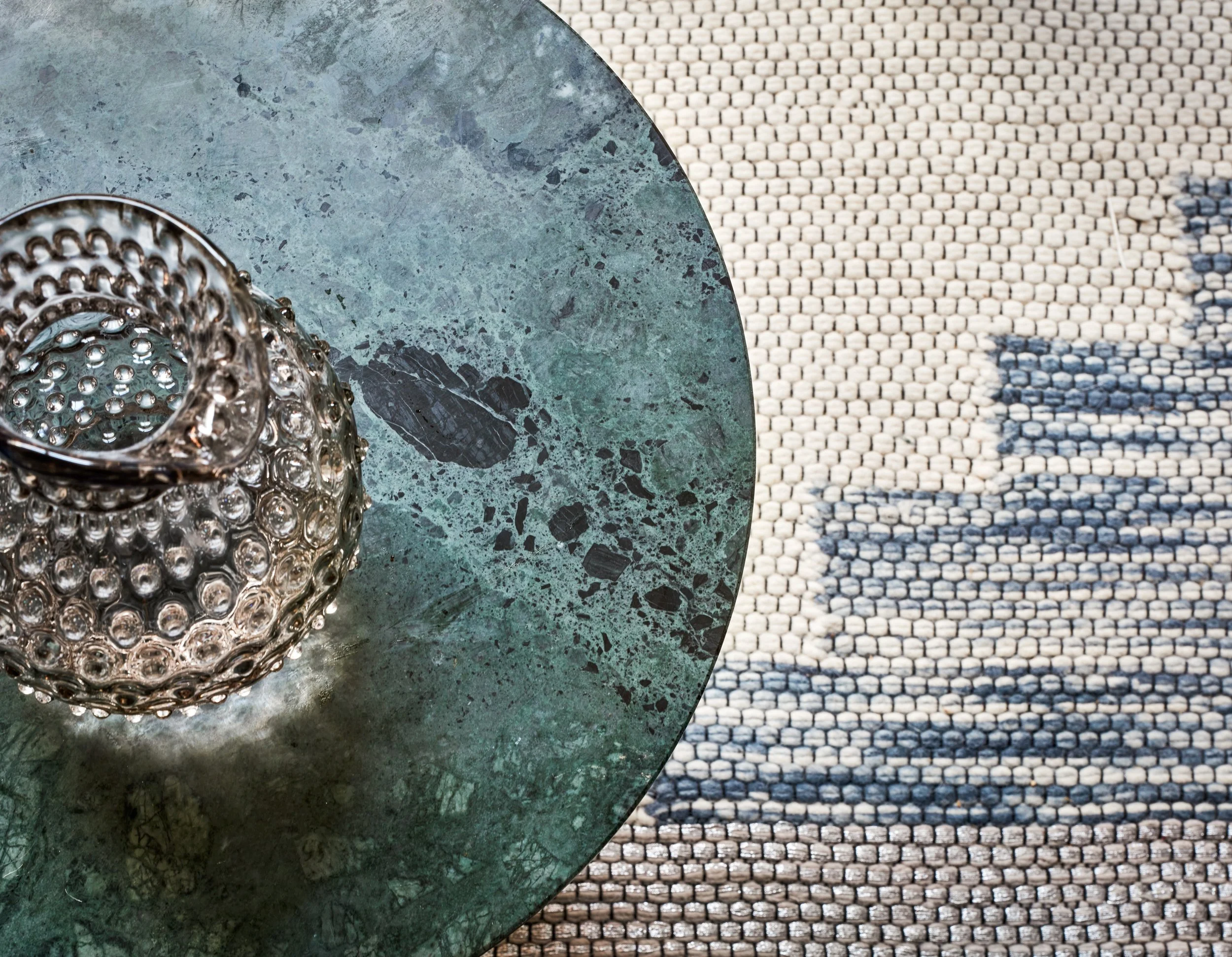 Cinema room design detail of a textured rug with a green marble coffee table I cinema room I London