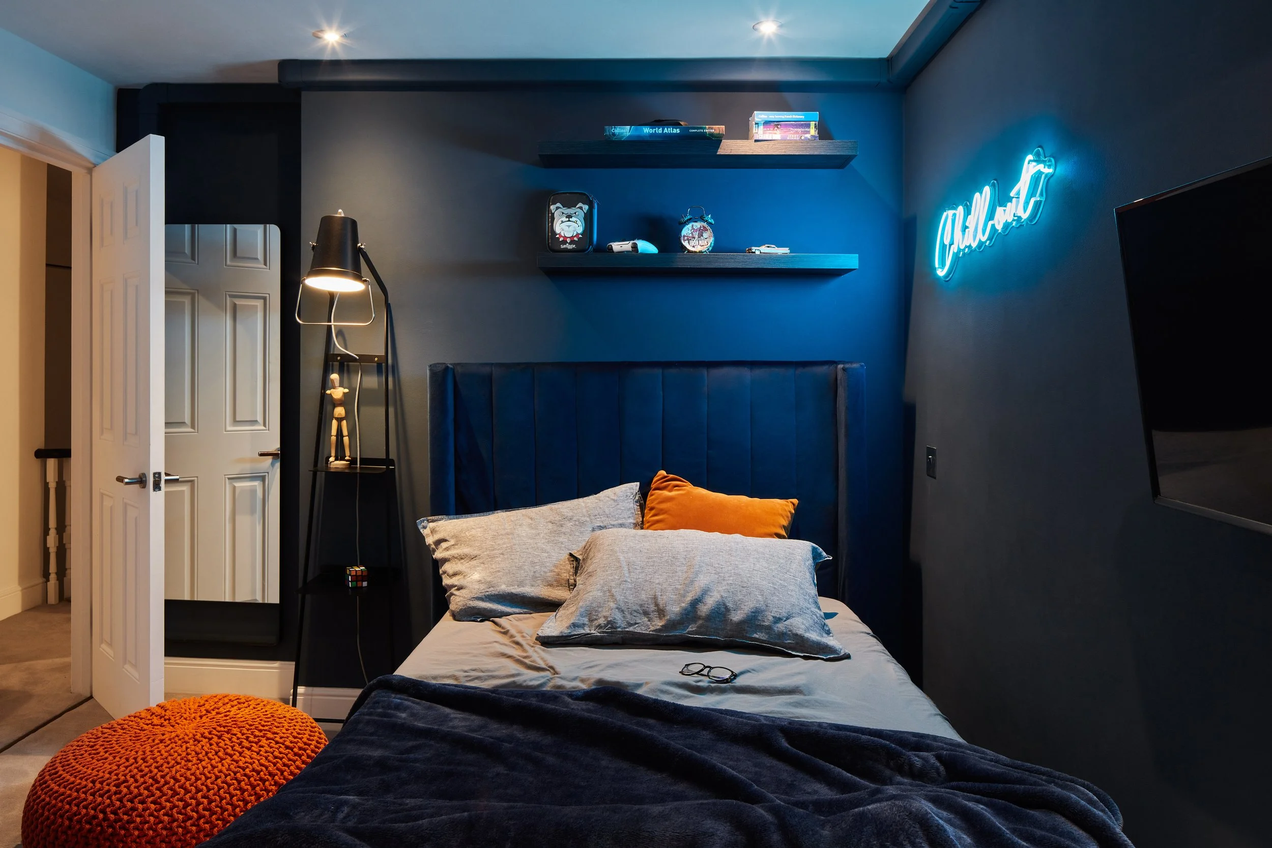 Teenage boy's bedroom with a technology-inspired design, featuring blue neon light and bold colors