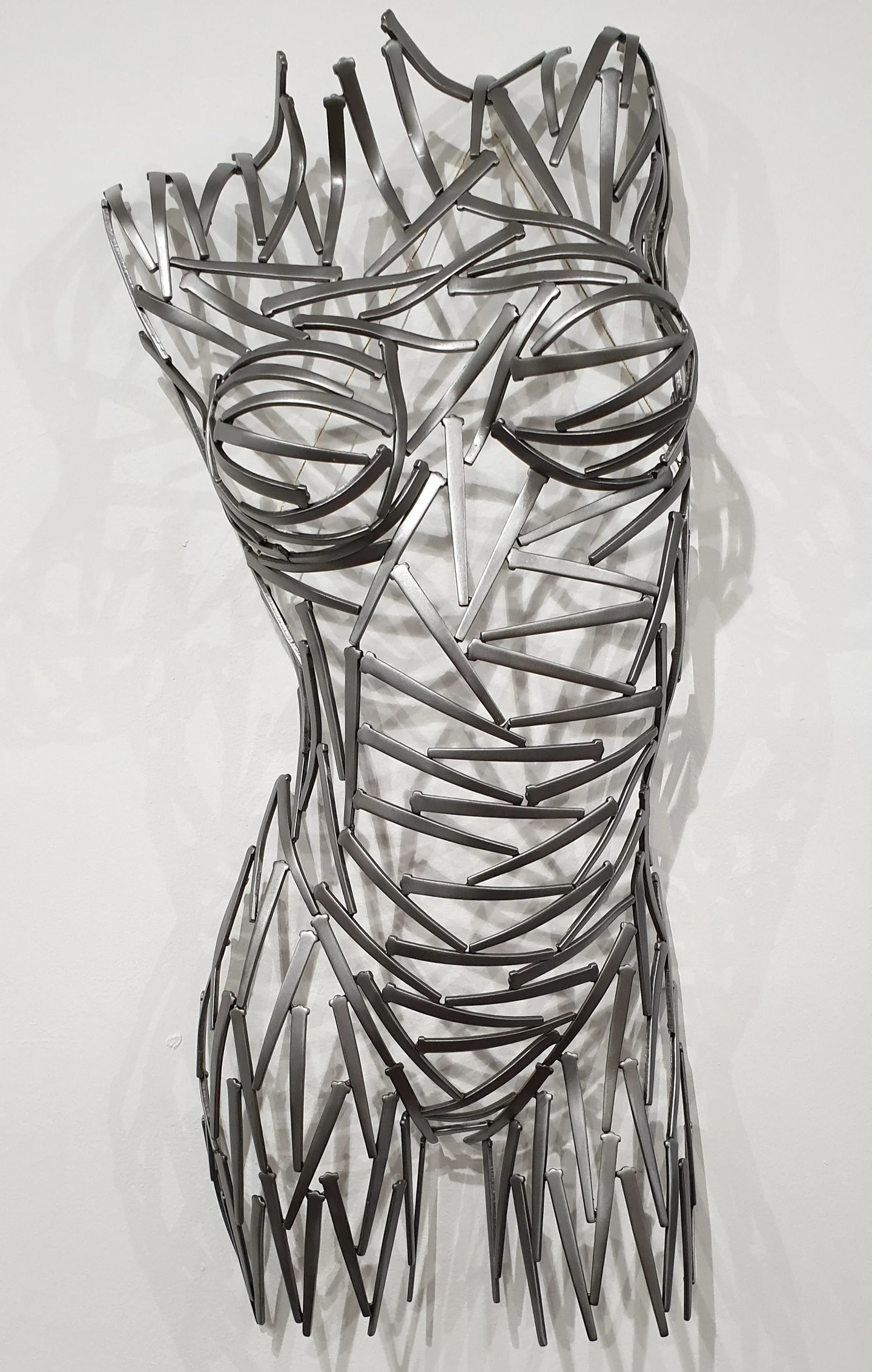 The original &ldquo;Nailed It&rdquo; takes on a new life in this sculptural interpretation of the female torso. Suspended on the wall, the form is built from individually welded metal pieces, each one shaped and positioned to create movement, depth, 