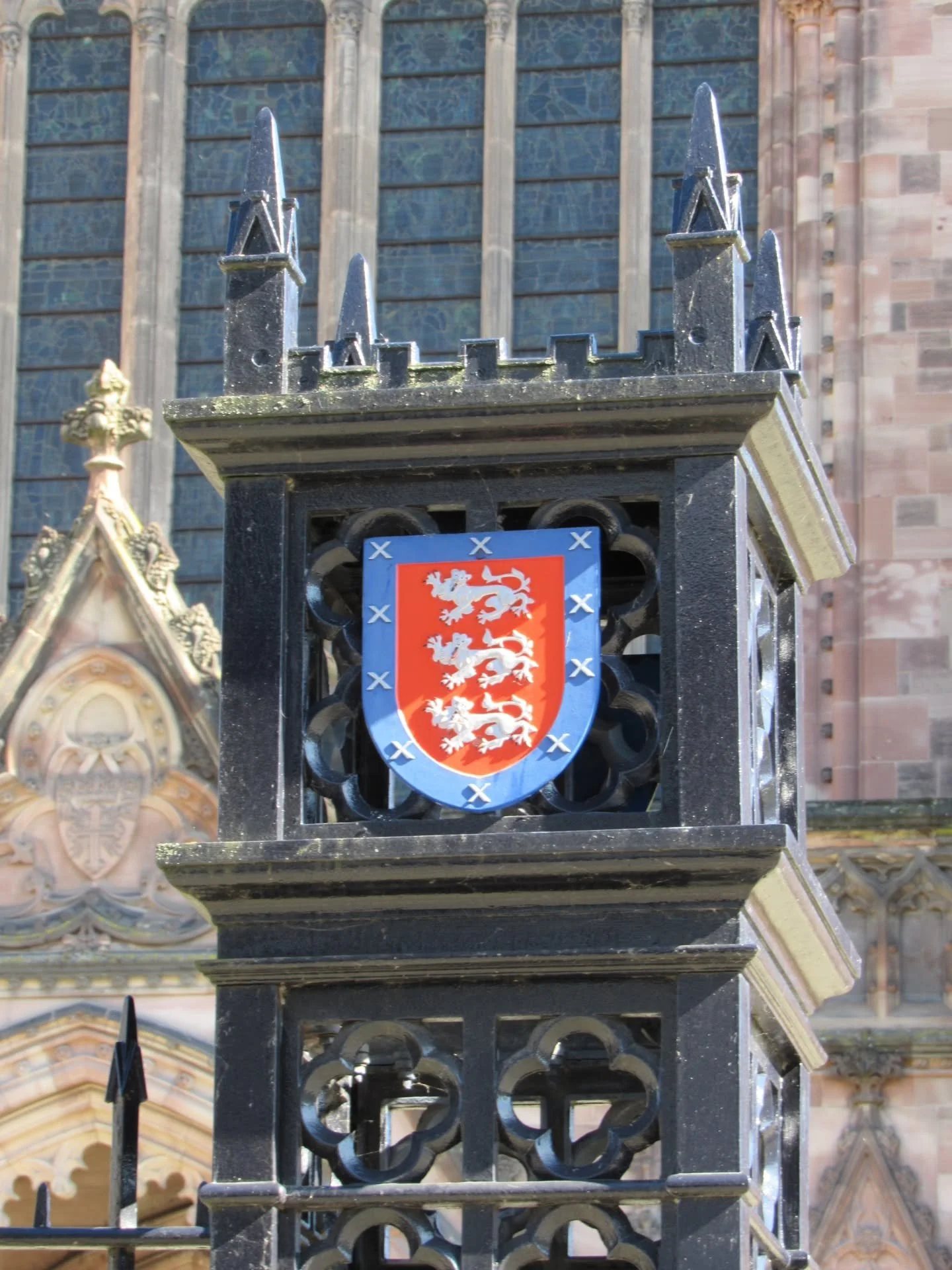 Dotted around on the fences and signposts surrounding Hereford Cathedral are a number of coats of arms, but what do they all represent?

The first is Hereford City's Coat of Arms, or at least the central shield of the arms. It contains three white dr