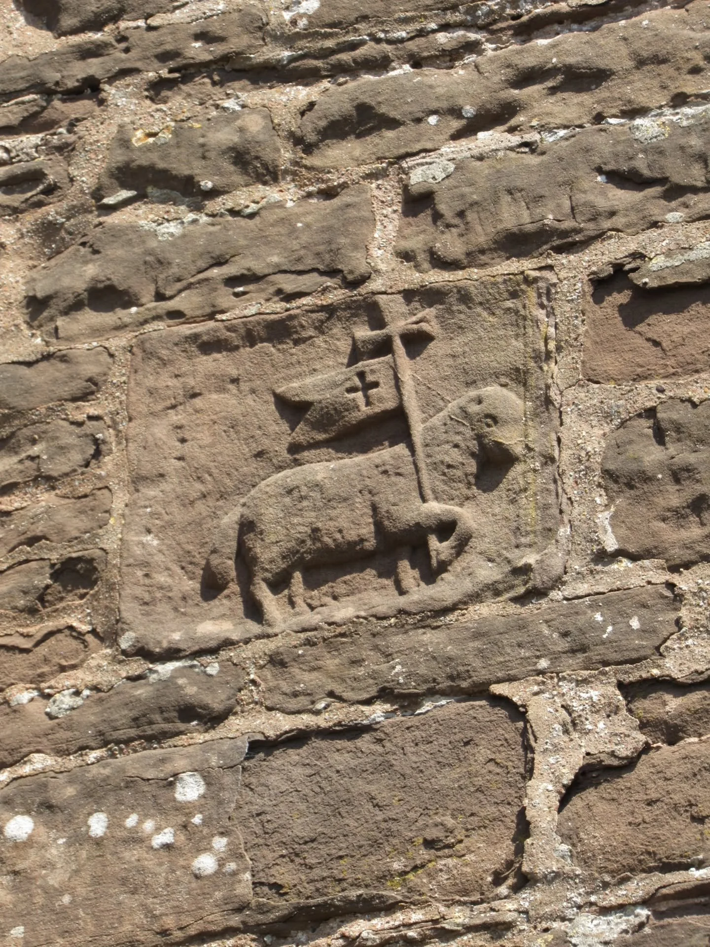 On the exterior of the south chapel of St Michael's Church, Garway, I spotted this Lamb of God (Agnus Dei), which symbolises Christ. 

It's holding a banner of victory, but is missing the halo above its head. I'm not very familiar with religious imag