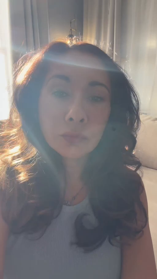 Stephanie beside a sunlit window with a pale blue light band across her forehead and curved light along her hair