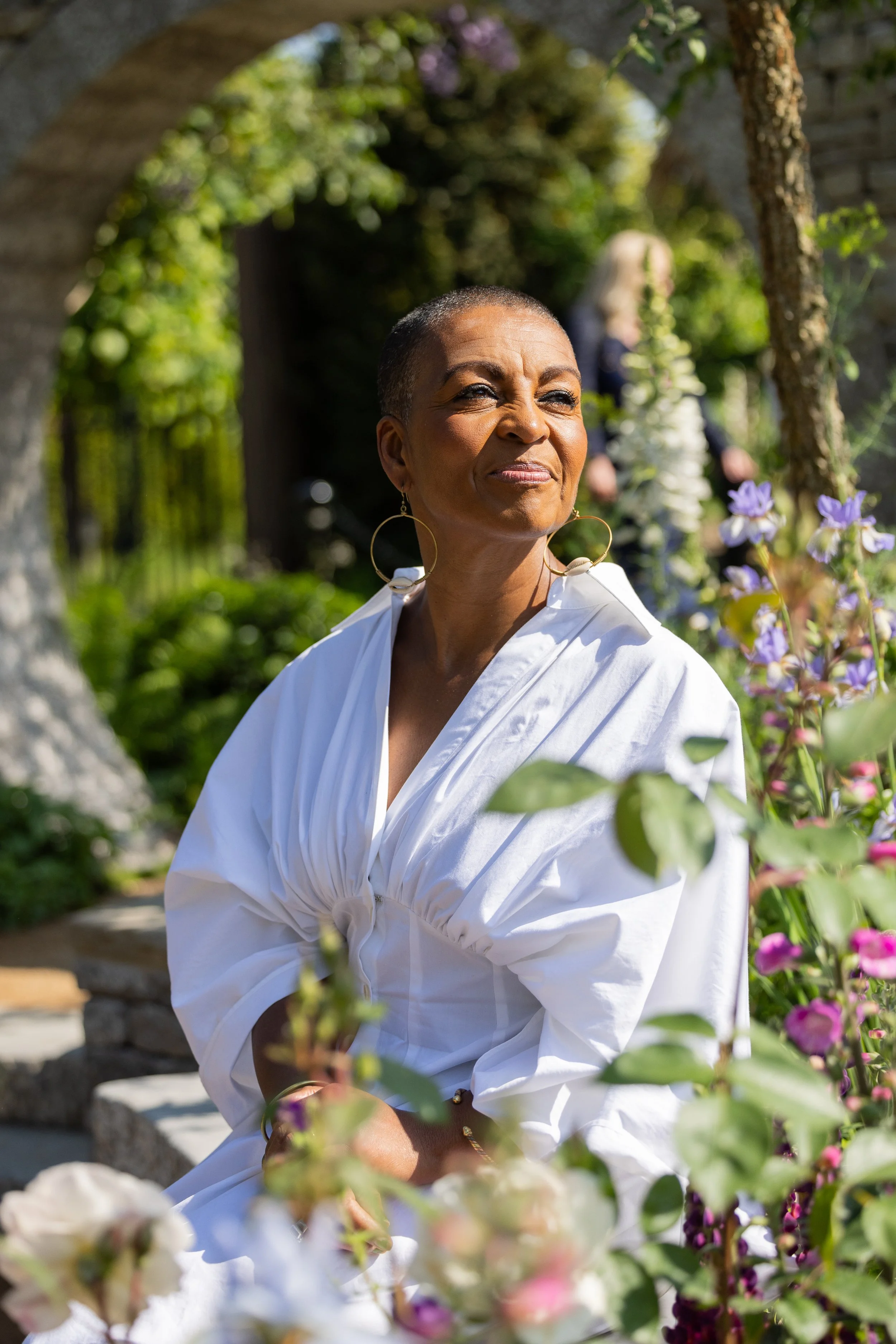 Bridgerton actress Adjoa Andoh sits in the Bridgerton Garden.