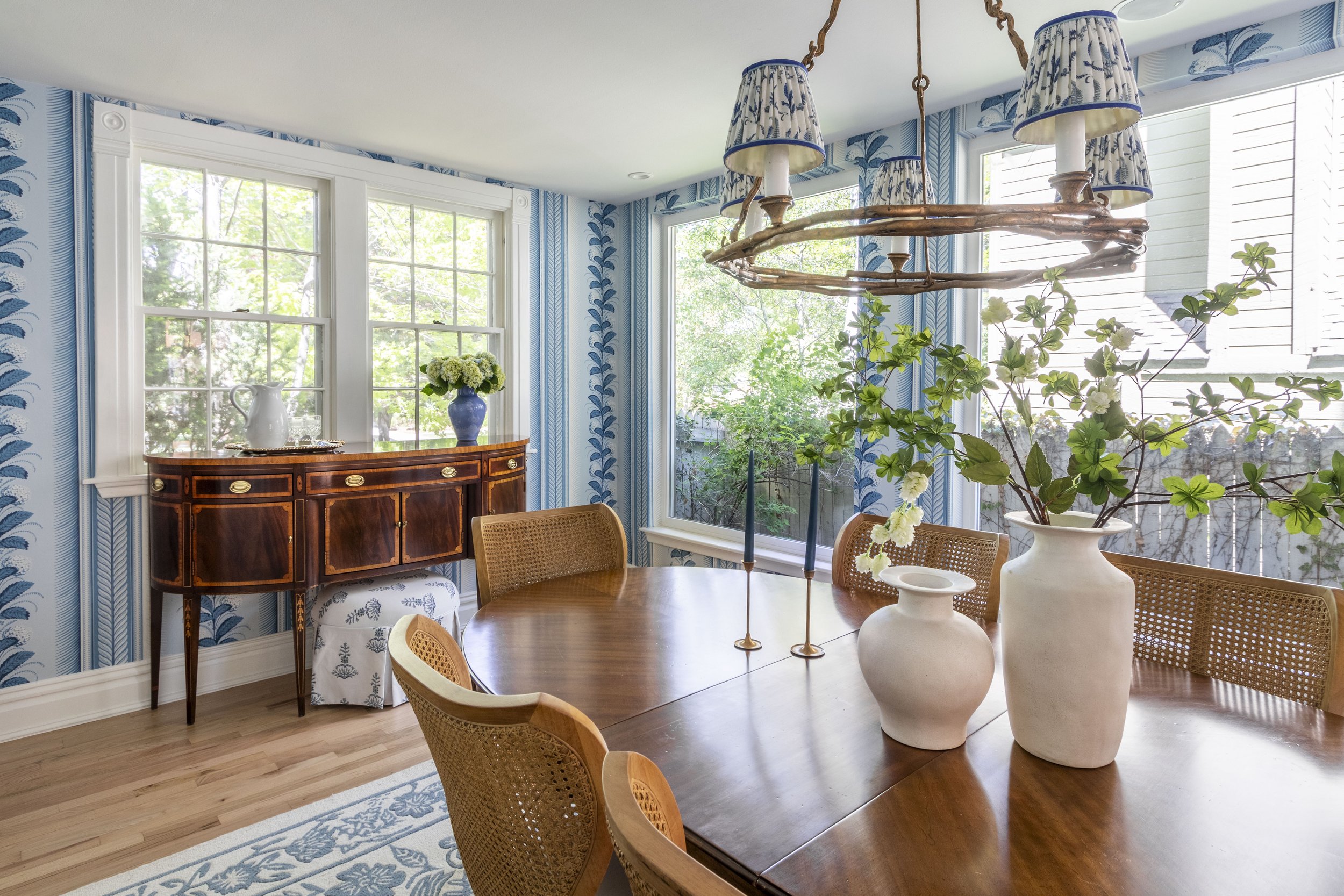 Transitional dining room in Denver Colorado with fun bright wallpaper and a vintage dining and buffet table.