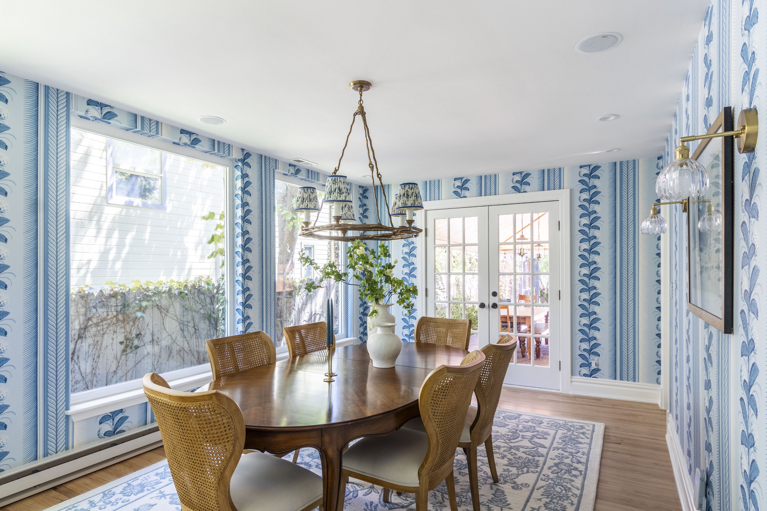 Transitional dining room in Denver Colorado with fun bright wallpaper and a vintage dining and buffet table.