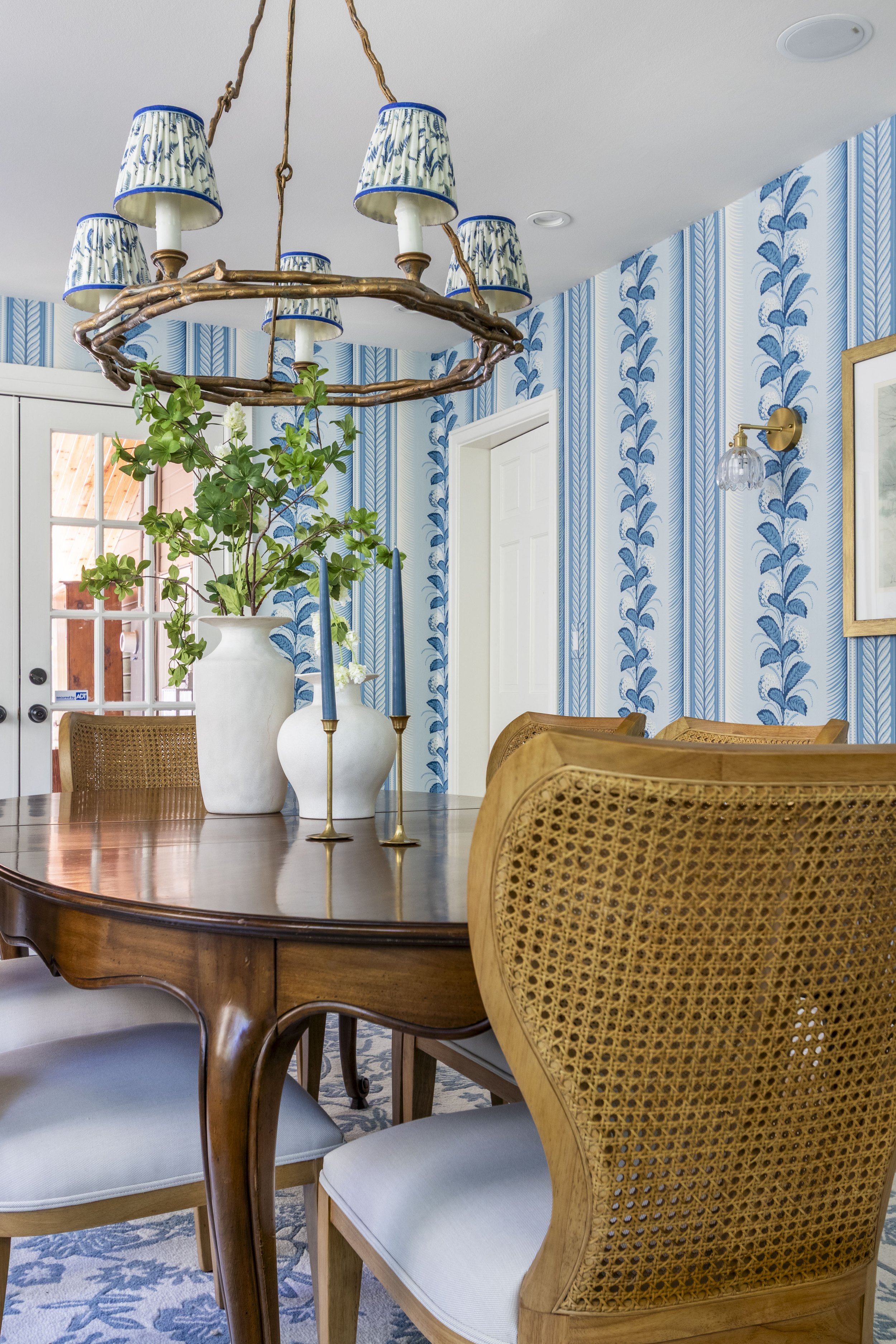 Transitional dining room with fun bright wallpaper and a vintage dining table.
