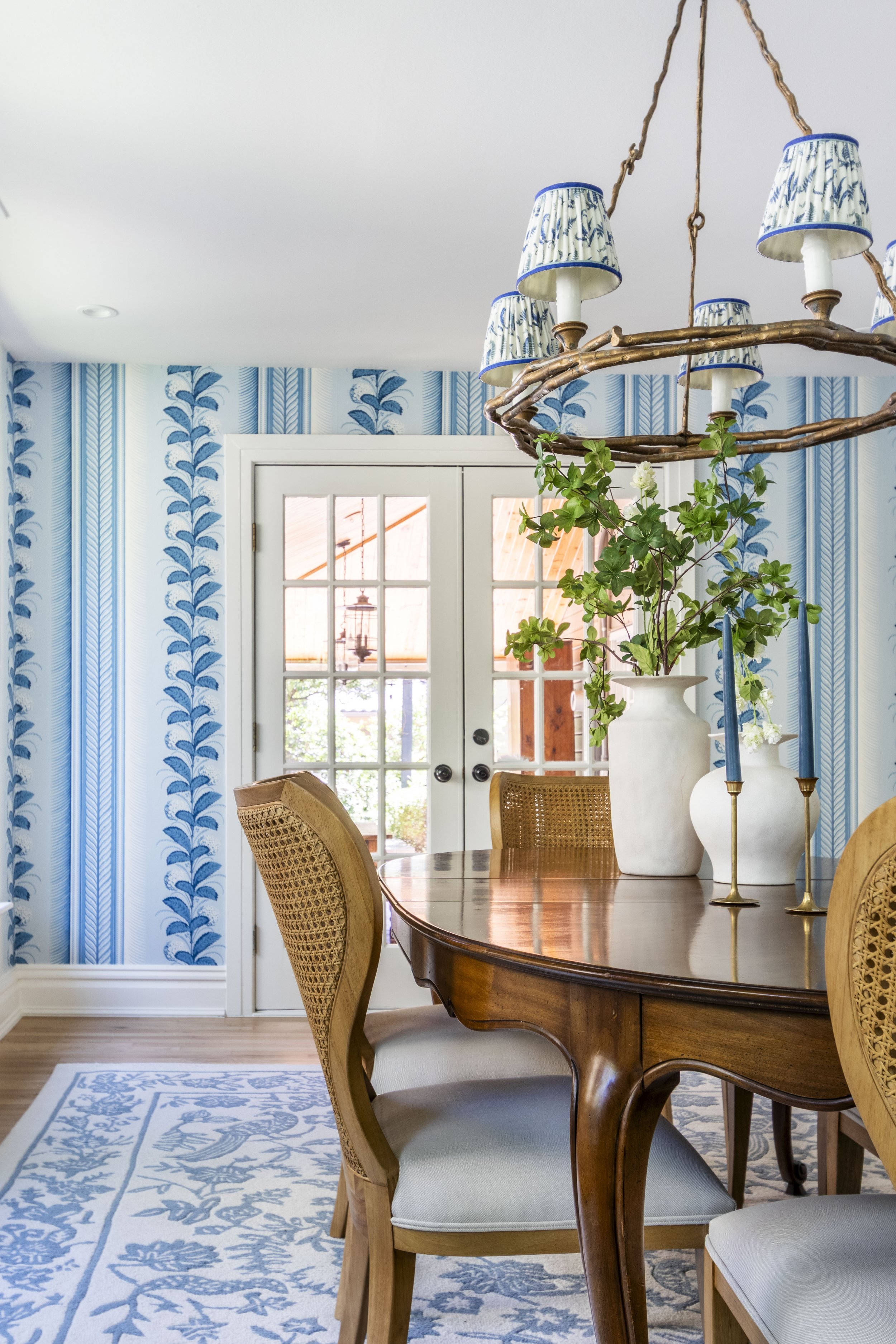 Transitional dining room with fun bright wallpaper and a vintage dining table.