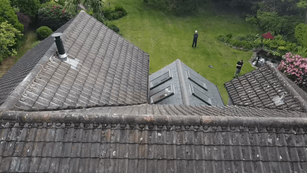 Aerial photograph of a tiled roof with rooflights and a garden beyond