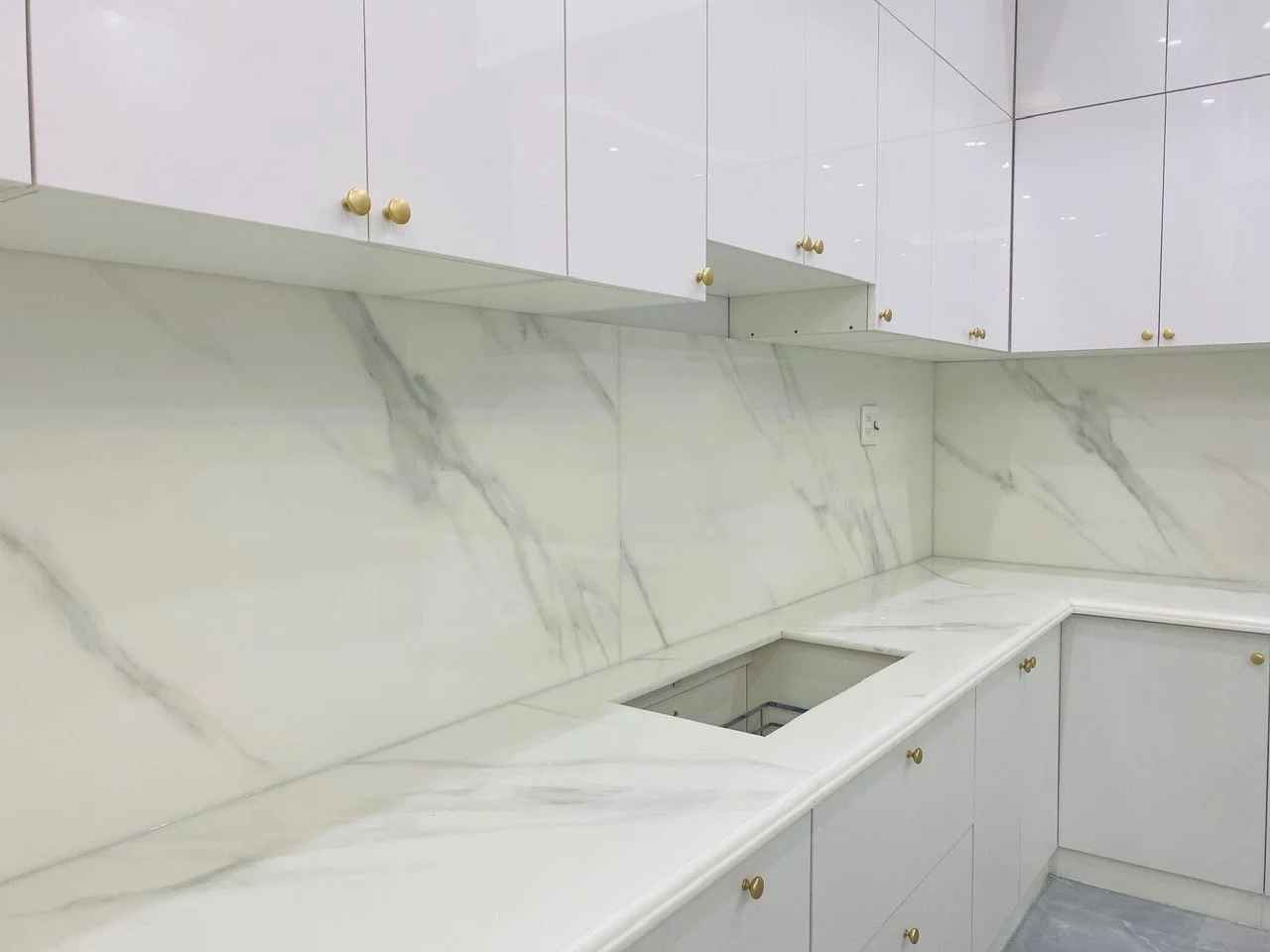 Modern kitchen interior with white marble countertops and cabinets