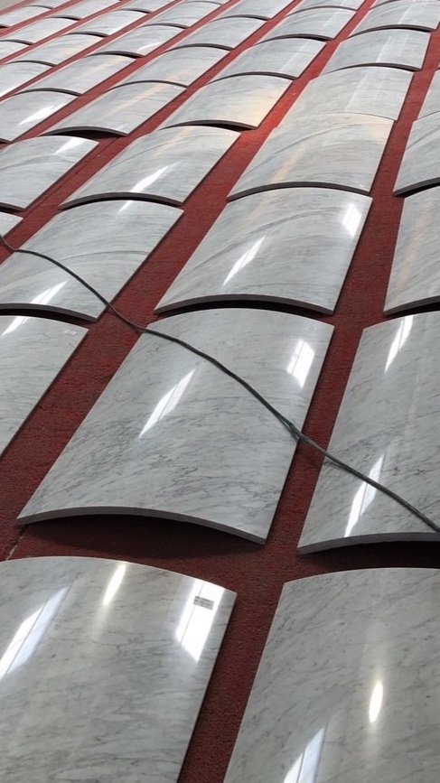 curved marble slabs displayed on a red surface
