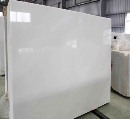 Large white marble slab in a warehouse