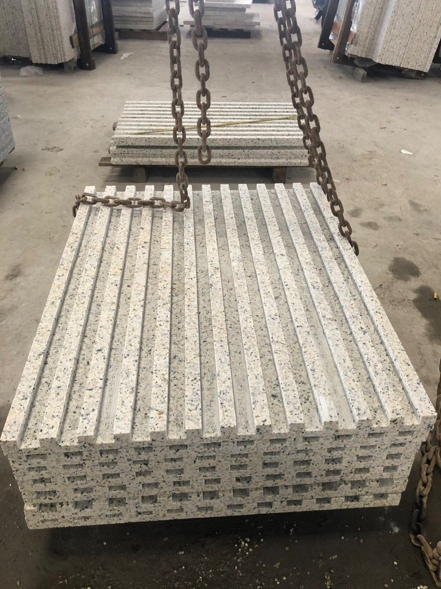 Granite slabs stacked with lifting chains