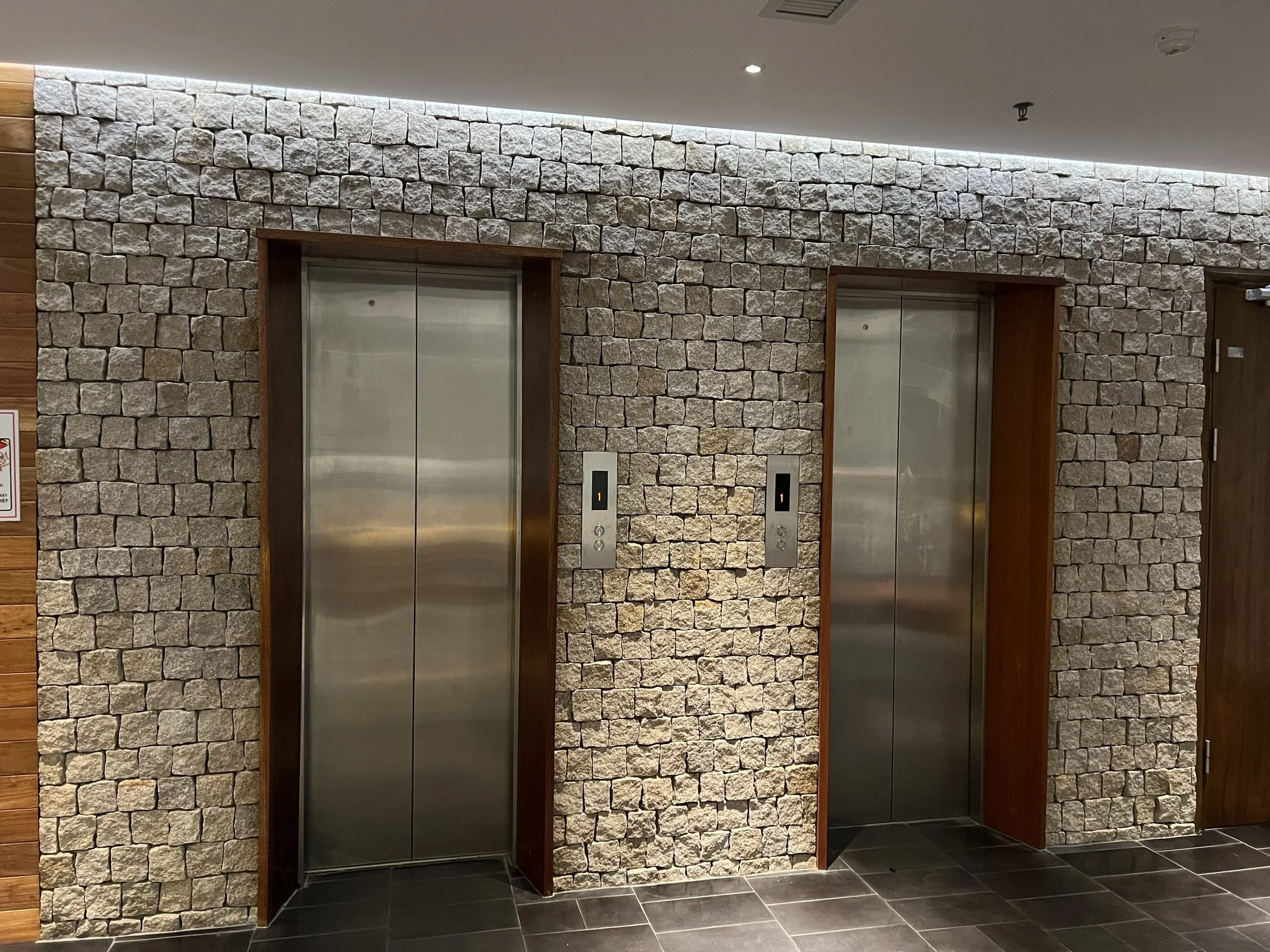 two elevators with stone wall cladding