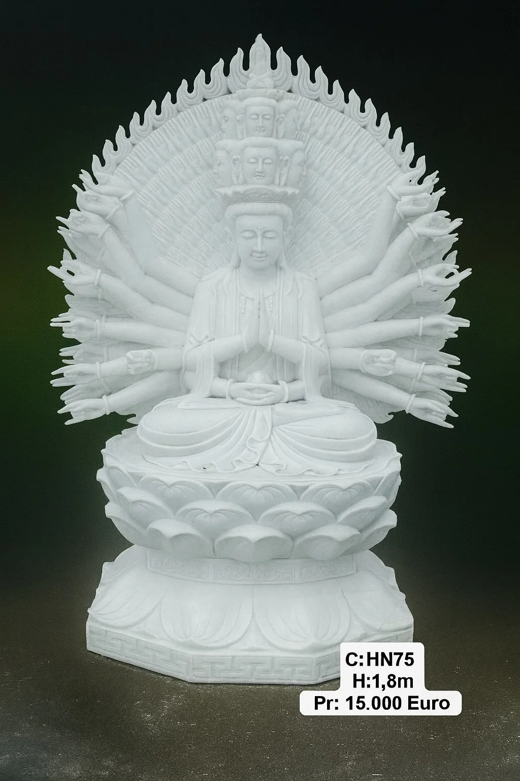 White sculpture of a multi-armed deity sitting on a lotus throne, with a serene expression and prayer hands, surrounded by a halo of smaller faces and flames.