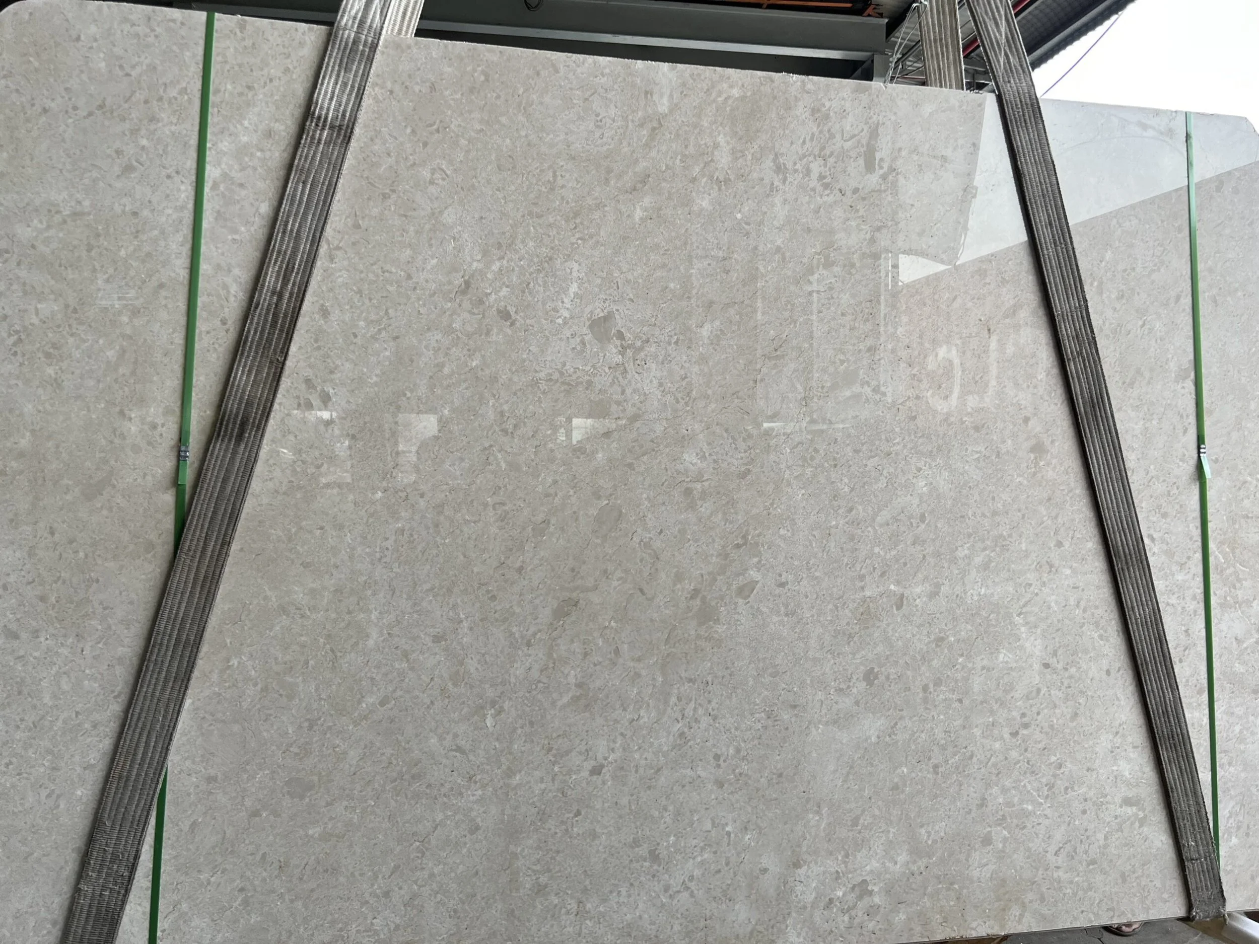 Large beige stone slab secured with straps