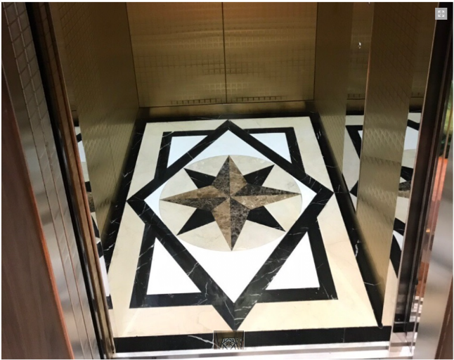 elevator interior with geometric floor design and brass walls