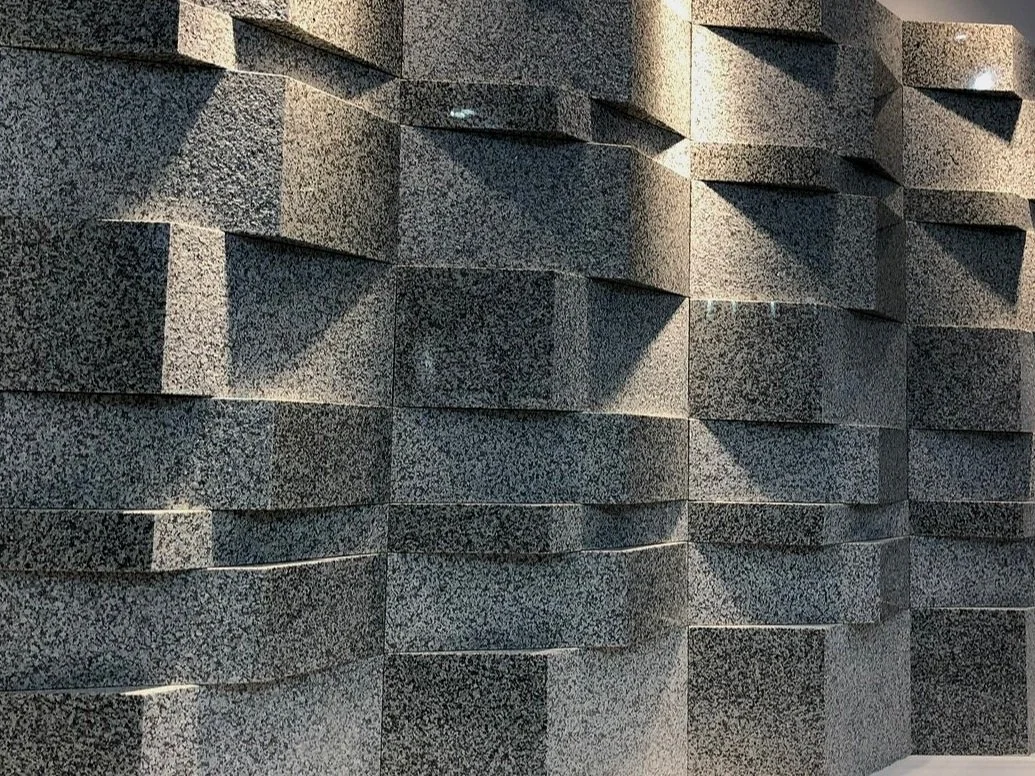 Textured stone wall with staggered blocks and shadows
