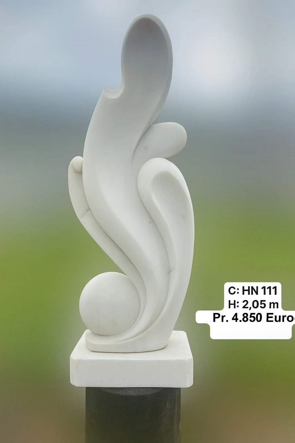 White abstract sculpture with curved shapes and circular elements on a square base, indoor or outdoor setting.
