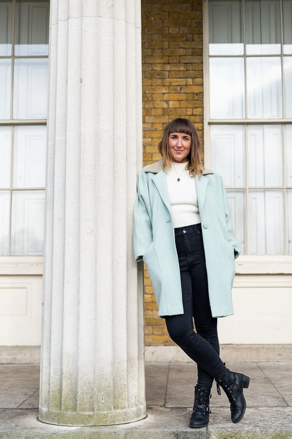 Dr Stephanie Minchin leaning against a stone column outside a building