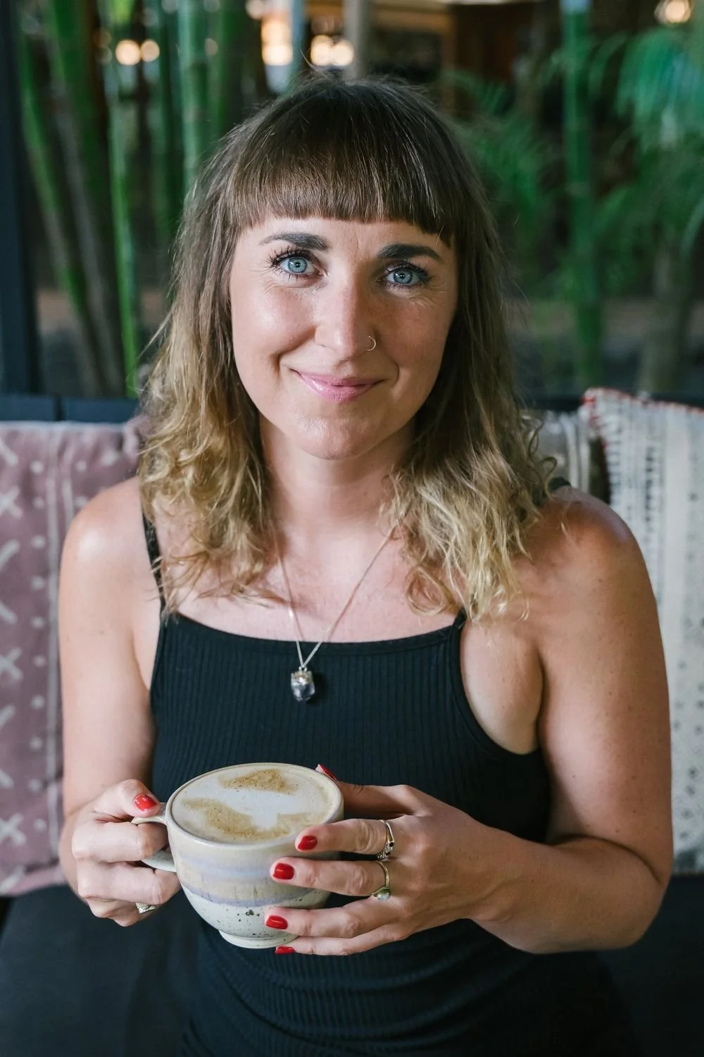 Dr Stephanie Minchin holding a cup of coffee, smiling to camera