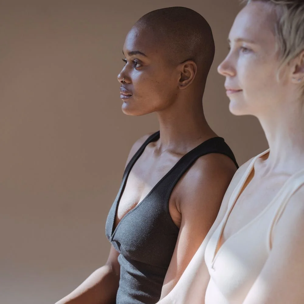 Two women in yoga wear standing side by side